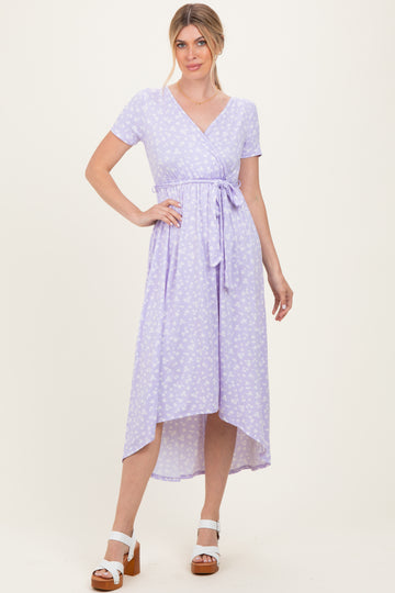 woman wearing a lavender floral wrap dress with short sleeves and a tie waist detail