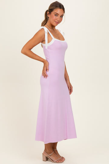 woman wearing a light purple maxi dress with white tie straps and a fitted bodice, posing sideways