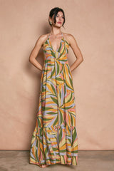 woman wearing a colorful floral maxi dress with a halter neck and tiered hem