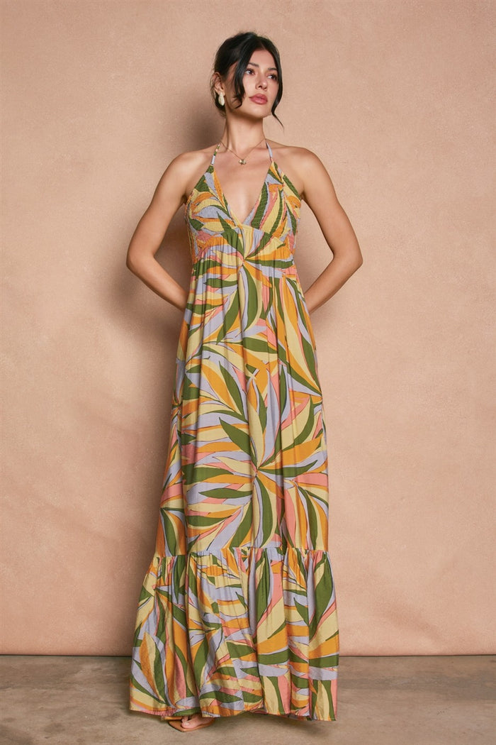 woman wearing a colorful floral maxi dress with a halter neck and tiered hem