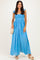 woman wearing a light blue maxi dress with ruffle straps and a smocked bodice, holding a woven bag and wearing platform sandals