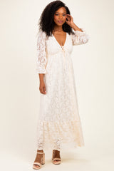 woman wearing a white lace maxi dress with a tie front and bell sleeves