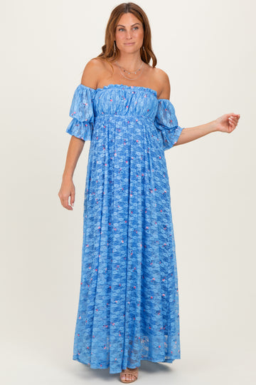 woman wearing a blue off-the-shoulder floral maxi dress with short ruffled sleeves