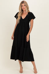 woman wearing a black tiered maxi dress with a v-neck and short puff sleeves