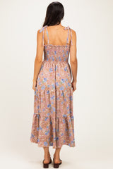 woman wearing a back view of a floral maxi dress with adjustable tie straps and a smocked bodice