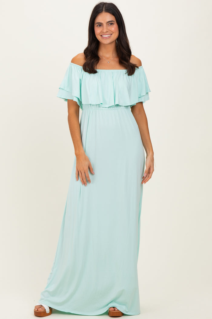 woman wearing a mint green off-the-shoulder maxi dress with ruffle details and a fitted waist
