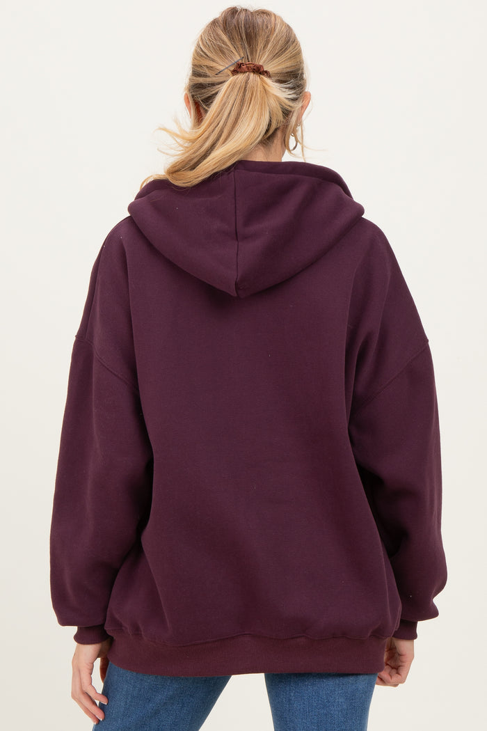 woman wearing a burgundy oversized hoodie, viewed from the back, suitable for maternity wear