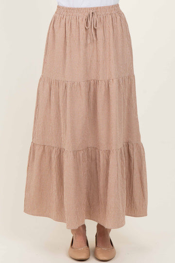 woman wearing a brown and white checked tiered maxi skirt with an elastic waistband and drawstring detail