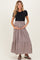 woman wearing a black short sleeve top and a striped tiered maternity maxi skirt, showing her baby bump