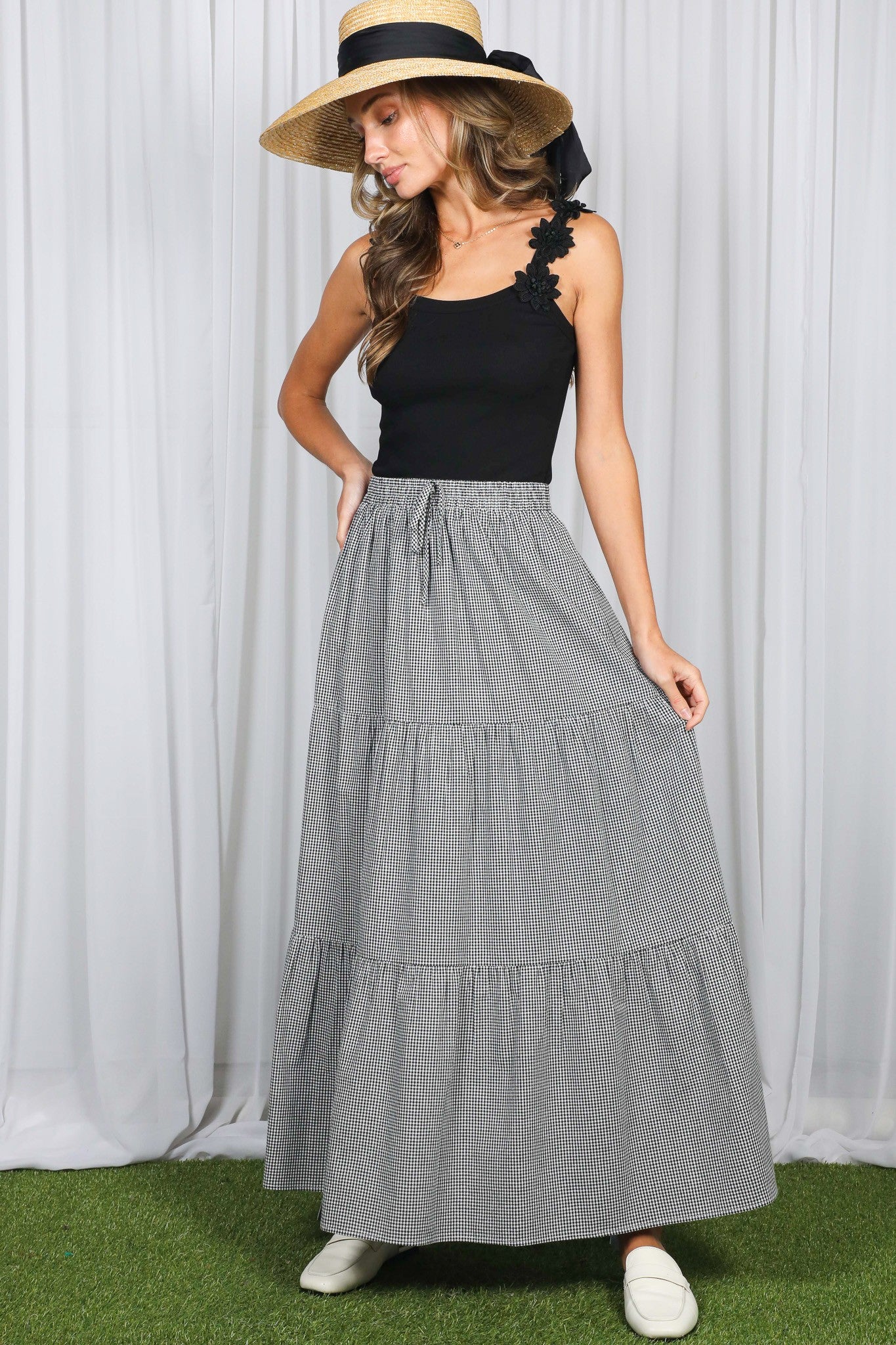 woman wearing a black tank top and a gray striped maxi skirt with tiers and a drawstring waist