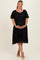 woman wearing a black maternity plus dress with short sleeves and lace detailing, holding her baby bump