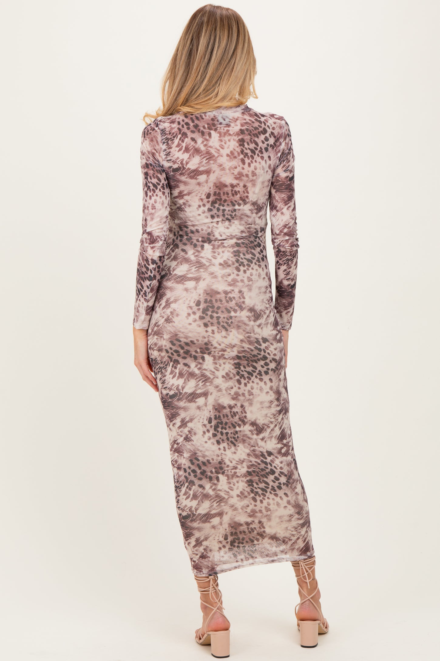 woman wearing a long sleeve maternity dress with a purple and beige abstract pattern, shown from the back