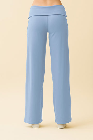 woman wearing light blue wide-leg lounge pants with a foldover waistband from the back
