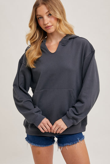 woman wearing a dark gray oversized hoodie and denim shorts