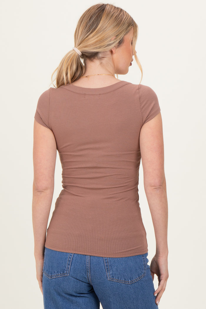 woman wearing a fitted brown ribbed short sleeve top, viewed from the back with loose light blue jeans
