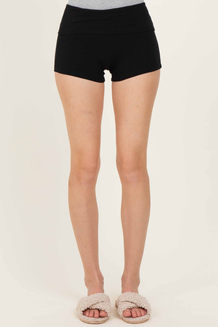 woman wearing black high-waisted shorts with a fitted style and soft texture, paired with fuzzy slippers