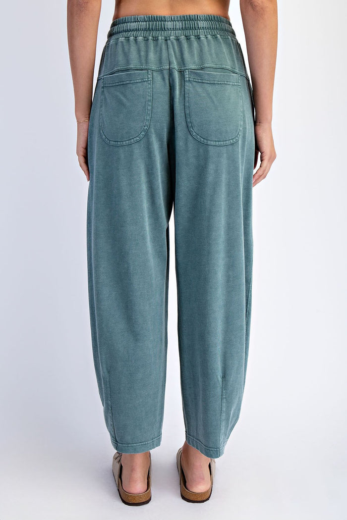 woman wearing light green relaxed fit pants with elastic waistband and two back pockets, seen from the back