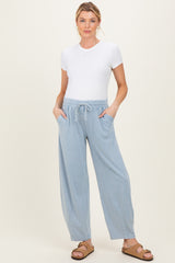 woman wearing a white short sleeve top and light blue maternity jogger pants with pockets
