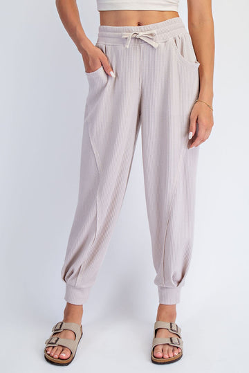 woman wearing light beige ribbed jogger pants with elastic cuffs and side pockets