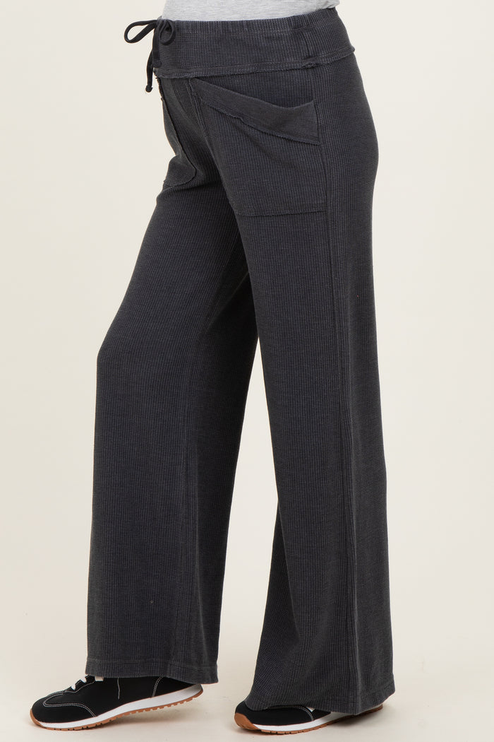 woman wearing dark gray maternity wide-leg pants with side pockets and a drawstring waist