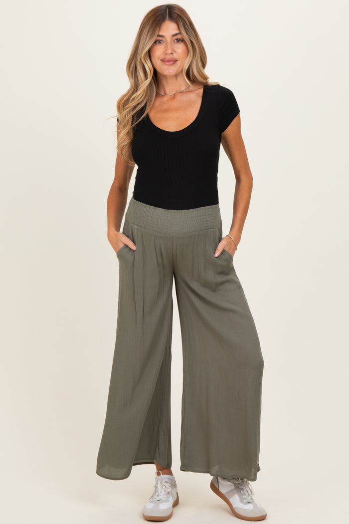 woman wearing a black ribbed scoop neck maternity top and olive green wide leg maternity pants with pockets
