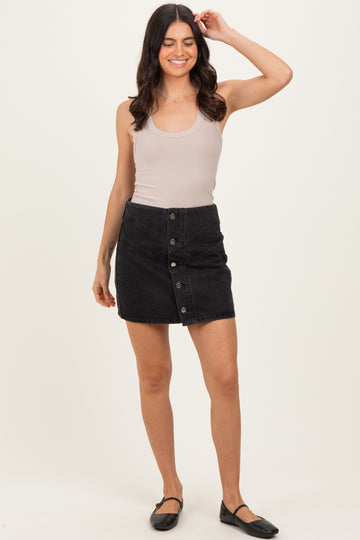 woman wearing a beige ribbed tank top and a black denim button-front skirt, styled with black ballet flats