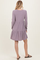 woman wearing a lavender striped long sleeve tiered dress, viewed from the back