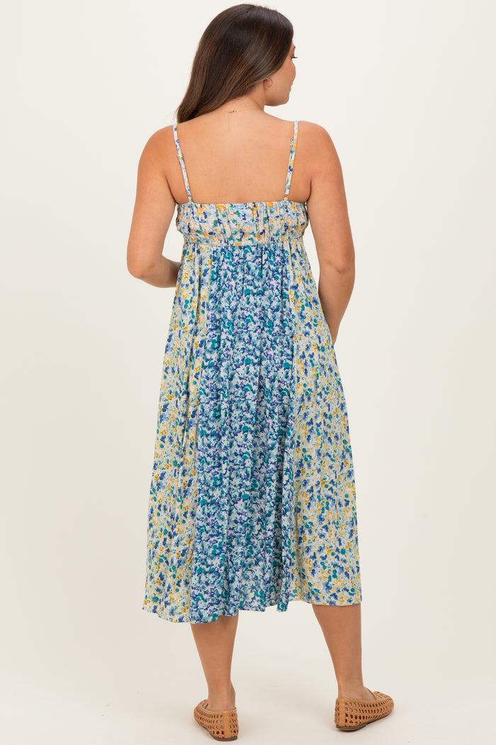 woman wearing a floral print maternity maxi dress with adjustable straps and a flowing silhouette