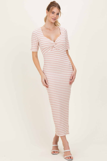 woman wearing a striped midi dress with a twisted front detail and short sleeves, standing in a neutral background