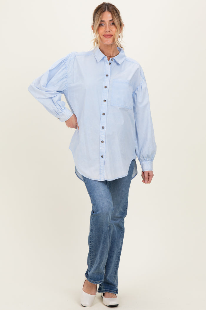 woman wearing a light blue maternity button-up shirt with puff sleeves and paired with jeans