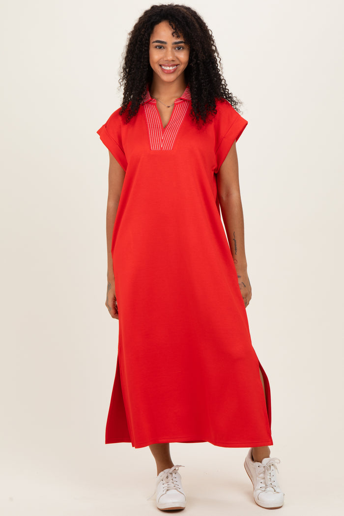 woman wearing a bright red short sleeve maxi dress with a v-neckline and side slits, styled with white sneakers