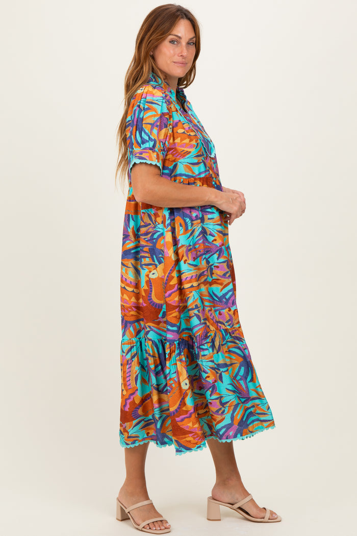 woman wearing a colorful tropical print midi dress with short sleeves and ruffle hem