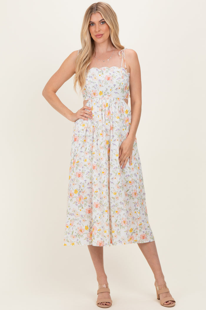 woman wearing a white floral midi sundress with adjustable spaghetti straps and a fitted bodice