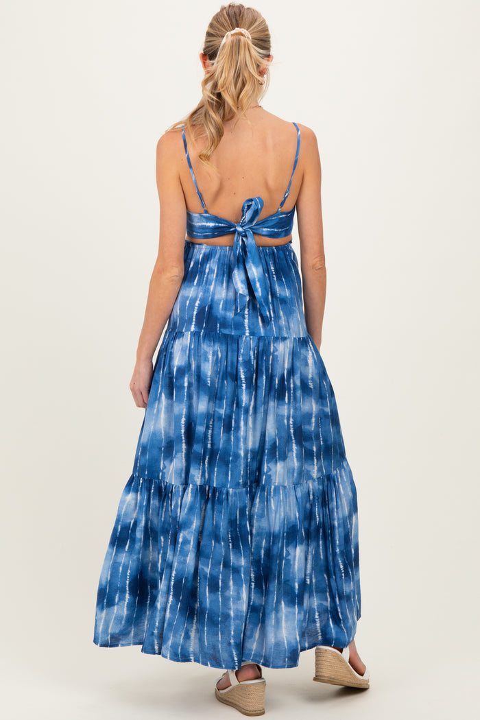 woman wearing a blue tie-dye maternity maxi dress with a back tie detail and tiered skirt