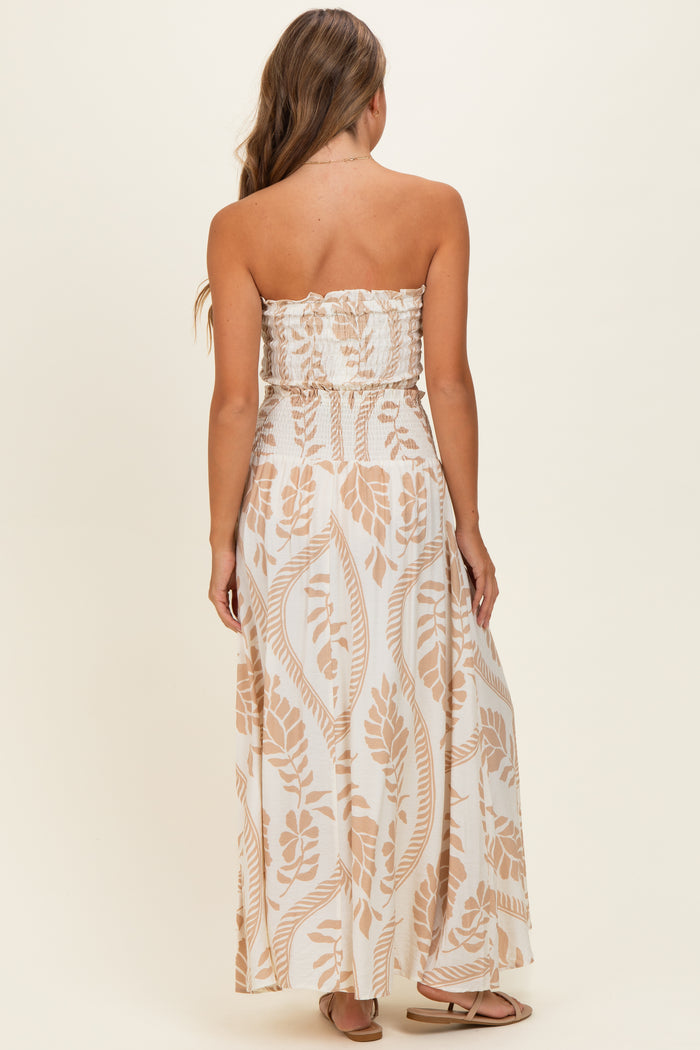 woman wearing a strapless beige and white patterned maxi dress with a smocked bodice, viewed from the back