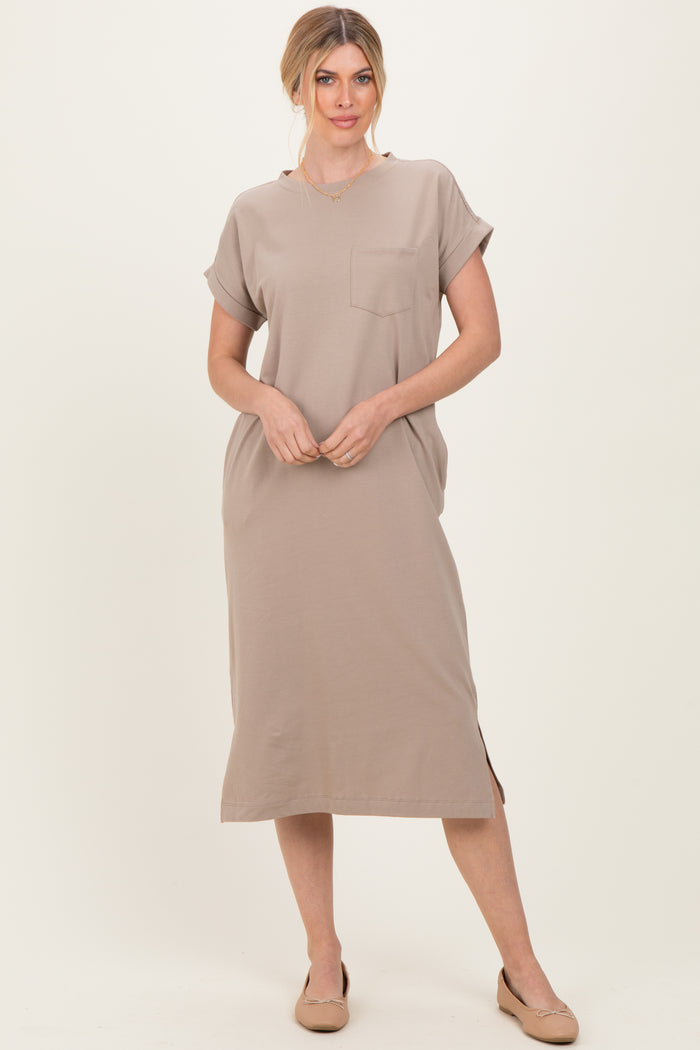 woman wearing a beige short sleeve midi dress with a pocket and side slit, styled with nude flats