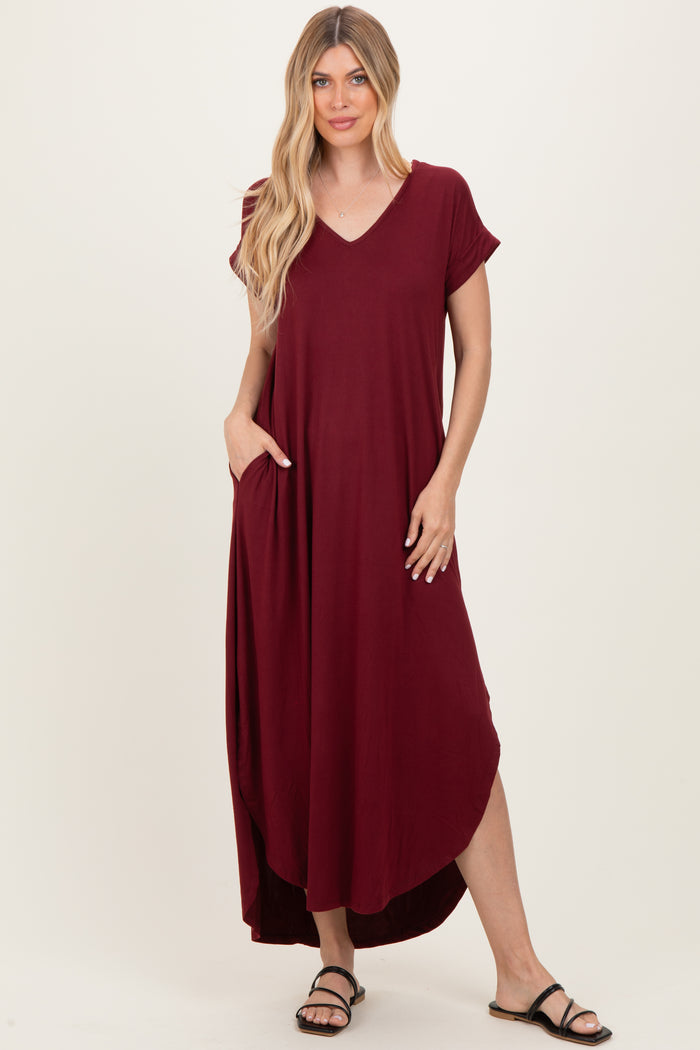 woman wearing a burgundy short sleeve maxi dress with pockets and a v-neckline