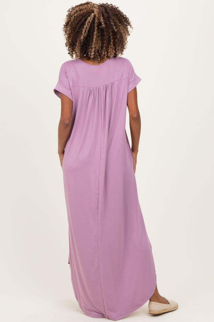 woman wearing a lavender maternity maxi dress with short sleeves and a relaxed fit, showing the back view