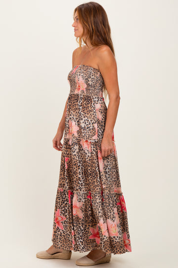 woman wearing a strapless maxi dress with a floral and animal print design in earthy tones
