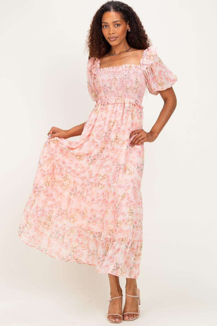 woman wearing a pink floral maxi dress with smocked bodice and puff sleeves