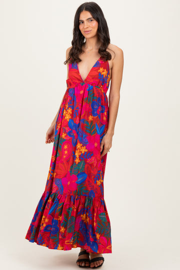 woman wearing a bright pink floral maxi dress with a deep V-neck and ruffled hem