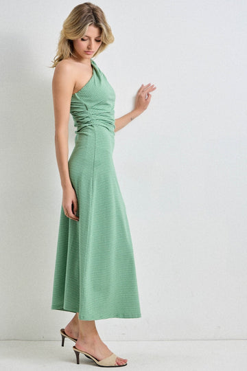 woman wearing a green one-shoulder midi dress with ruched detailing and high heels