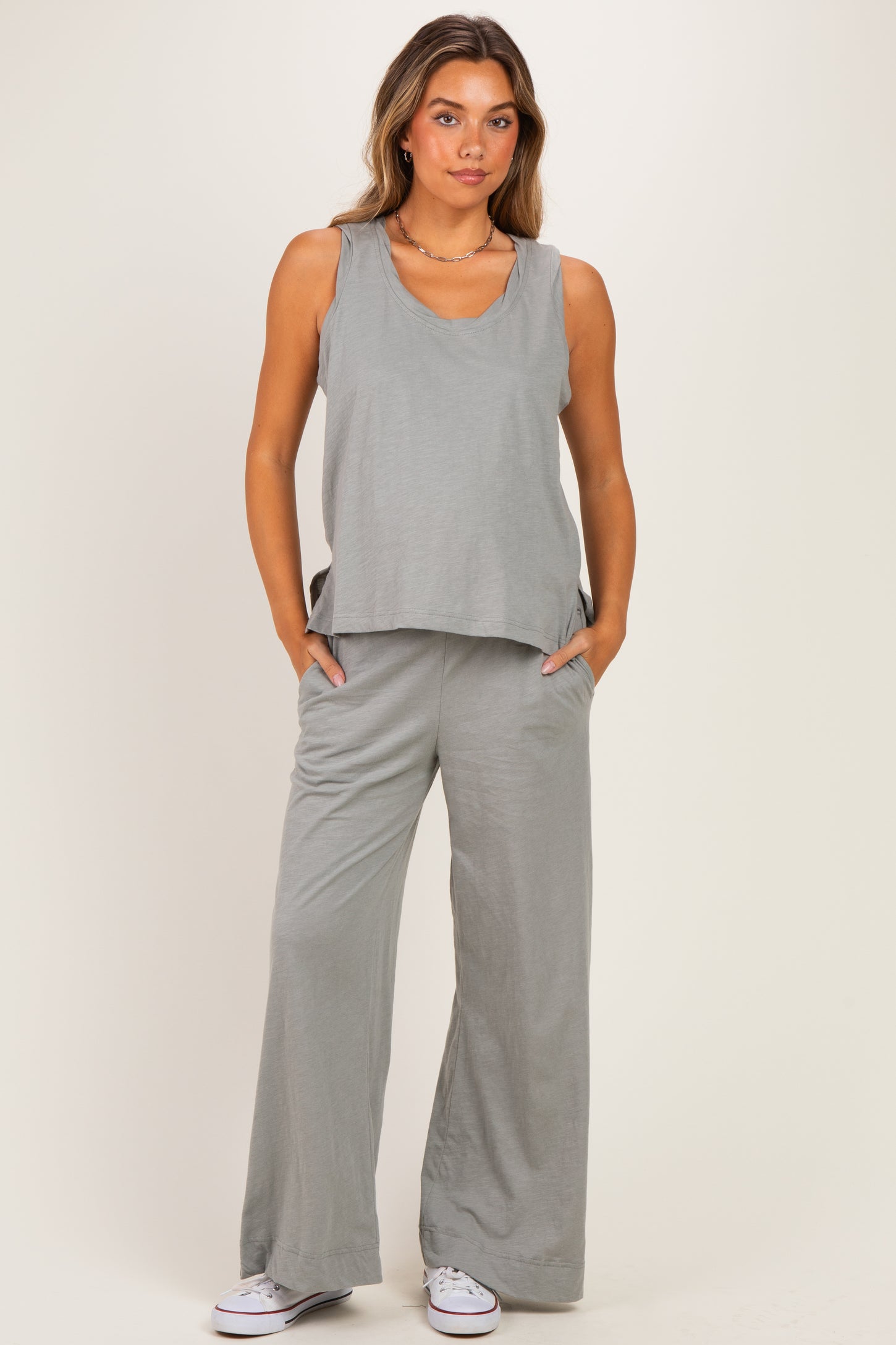 woman wearing a gray maternity tank top and matching wide-leg pants with pockets