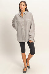 woman wearing a striped oversized button-up shirt with long sleeves and black leggings