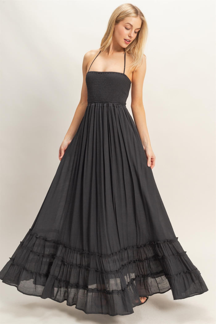 woman wearing a black strapless maxi dress with a smocked bodice and ruffled hem