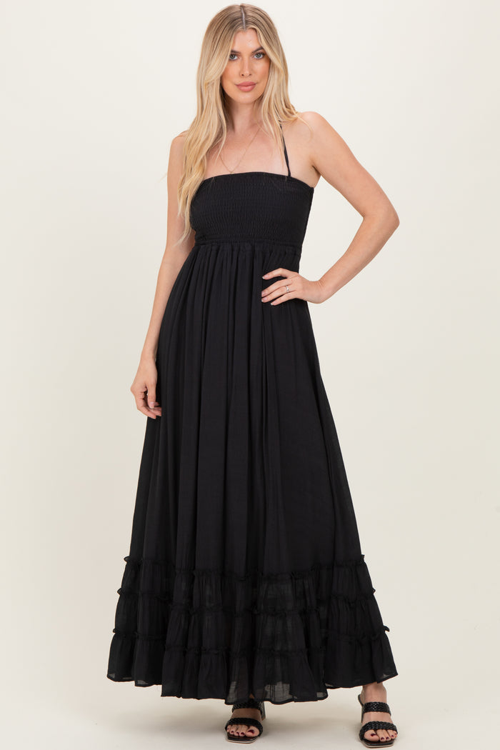 woman wearing a black strapless maxi dress with a smocked bodice and ruffled hem