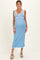 woman wearing a light blue maternity dress with white trim and a tie detail, showcasing her baby bump