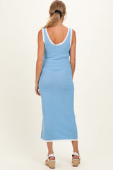 woman wearing a light blue maternity maxi dress with a scalloped neckline and back details, showing a baby bump