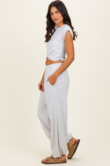 woman wearing a light gray cropped t-shirt and matching wide-leg pants with pockets