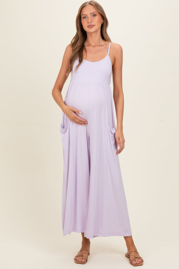woman wearing a lavender maternity maxi dress with pockets and holding her baby bump
